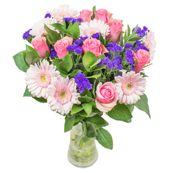 As a florist rooted in the Petts Wood community, I take joy in creating arrangements that reflect both local warmth and refined artistry. This particular bouquet invites you into a world of soft, harmonious colour: pastel-pink gerberas, their velvety petals reminiscent of spring mornings in Willett Woods, nestle beside pink roses unfurling with elegant poise. Striking, violet sprigs of statice punctuate the arrangement, their deep hue a playful counterpoint amid the gentle blush, much like the contrast found in Petts Wood's bustling shops against tranquil green spaces. Dew-bright leaves anchor the blooms, adding a cool, invigorating touch that brings to mind the freshness of a garden after rain. Arranged in a minimalist glass vase, the whole bouquet glows softly-a mix of lightness and vitality that feels at once uplifting and serene. Whether destined for a celebratory birthday table or as an unexpected gesture of encouragement to a friend nearby, every blossom speaks of thoughtful craftsmanship and local pride. This arrangement is a testament to the artistry and care found at Flowers Petts Wood, celebrating the everyday moments that make our neighbourhood unique.